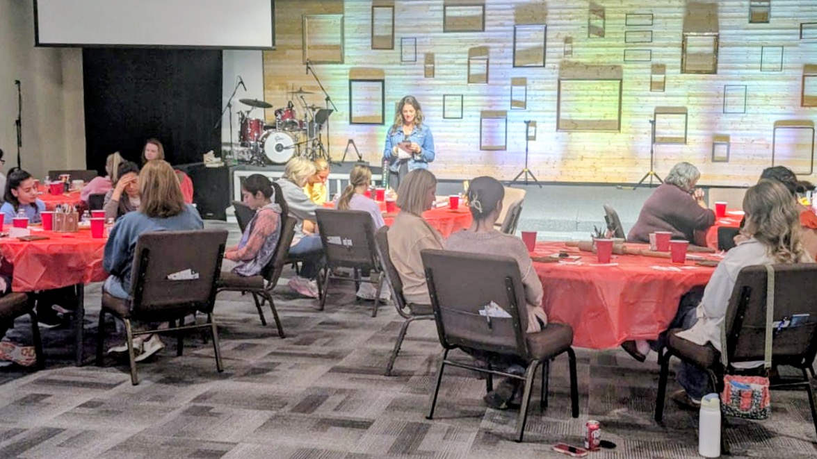 Guests seated at round tables during a group pottery workshop