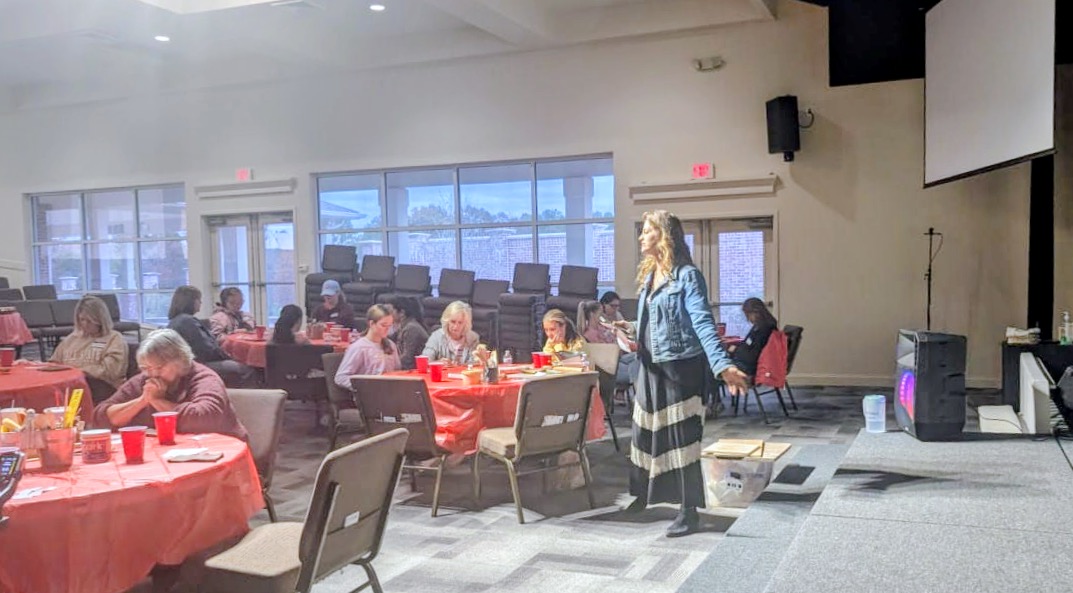 April Dupuis leading a pottery workshop for a seated group