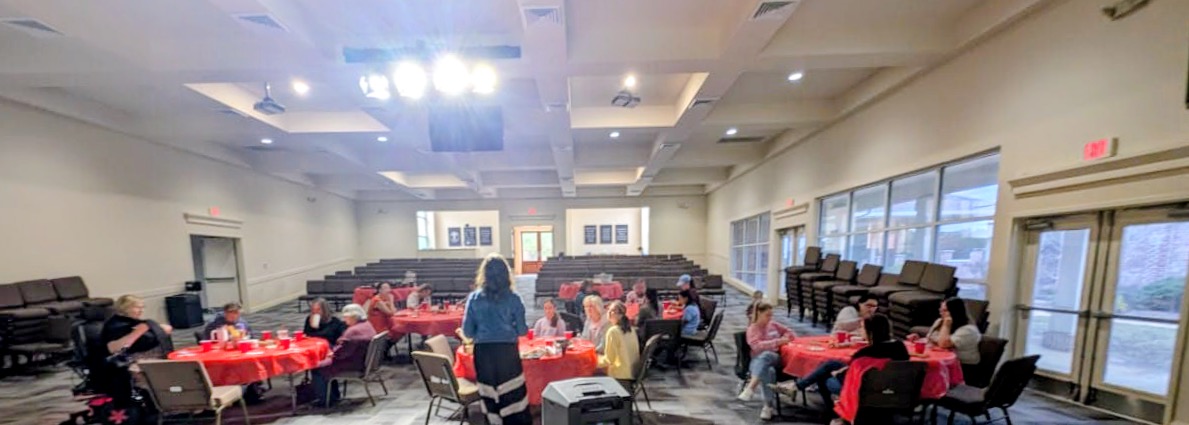 A full room of participants working at tables during a group pottery workshop